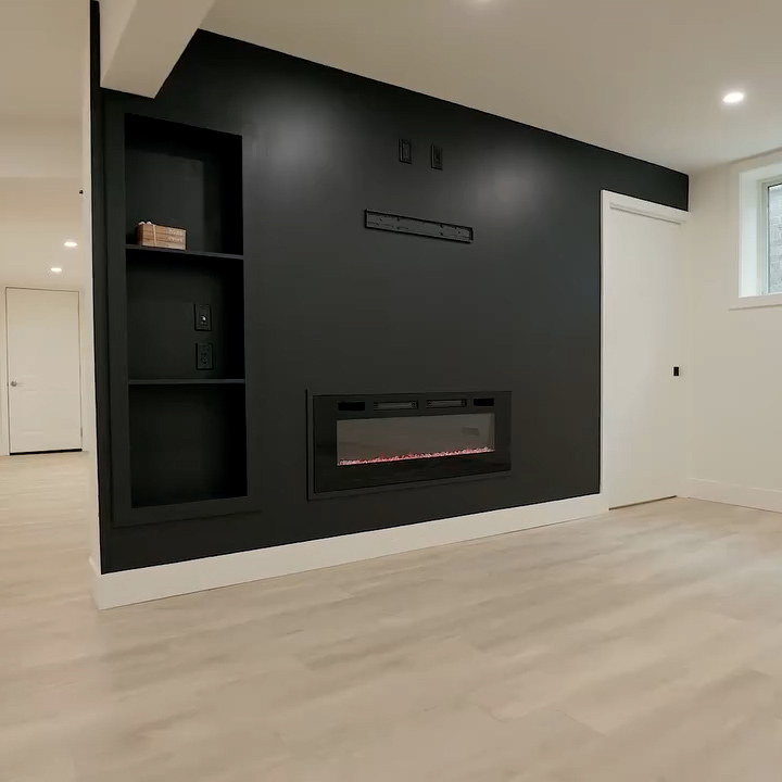 Black accent wall with built-in fireplace and pocket shelving